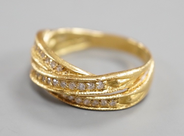 A modern 18ct gold and diamond chip set crossover ring, size N, gross weight 5.2 grams.